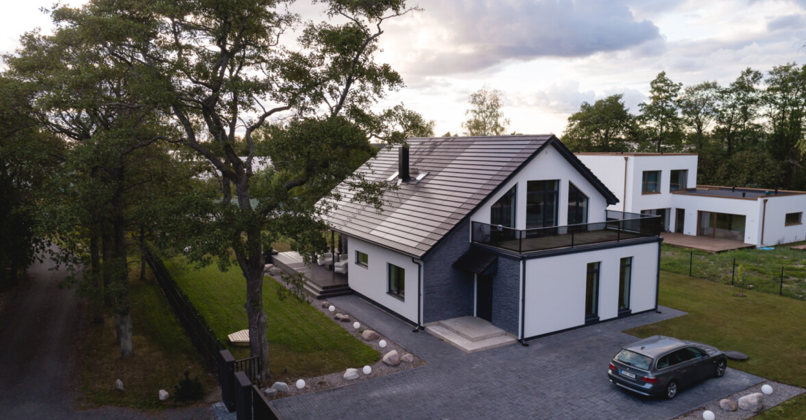 modern house with solar tiled roof and car