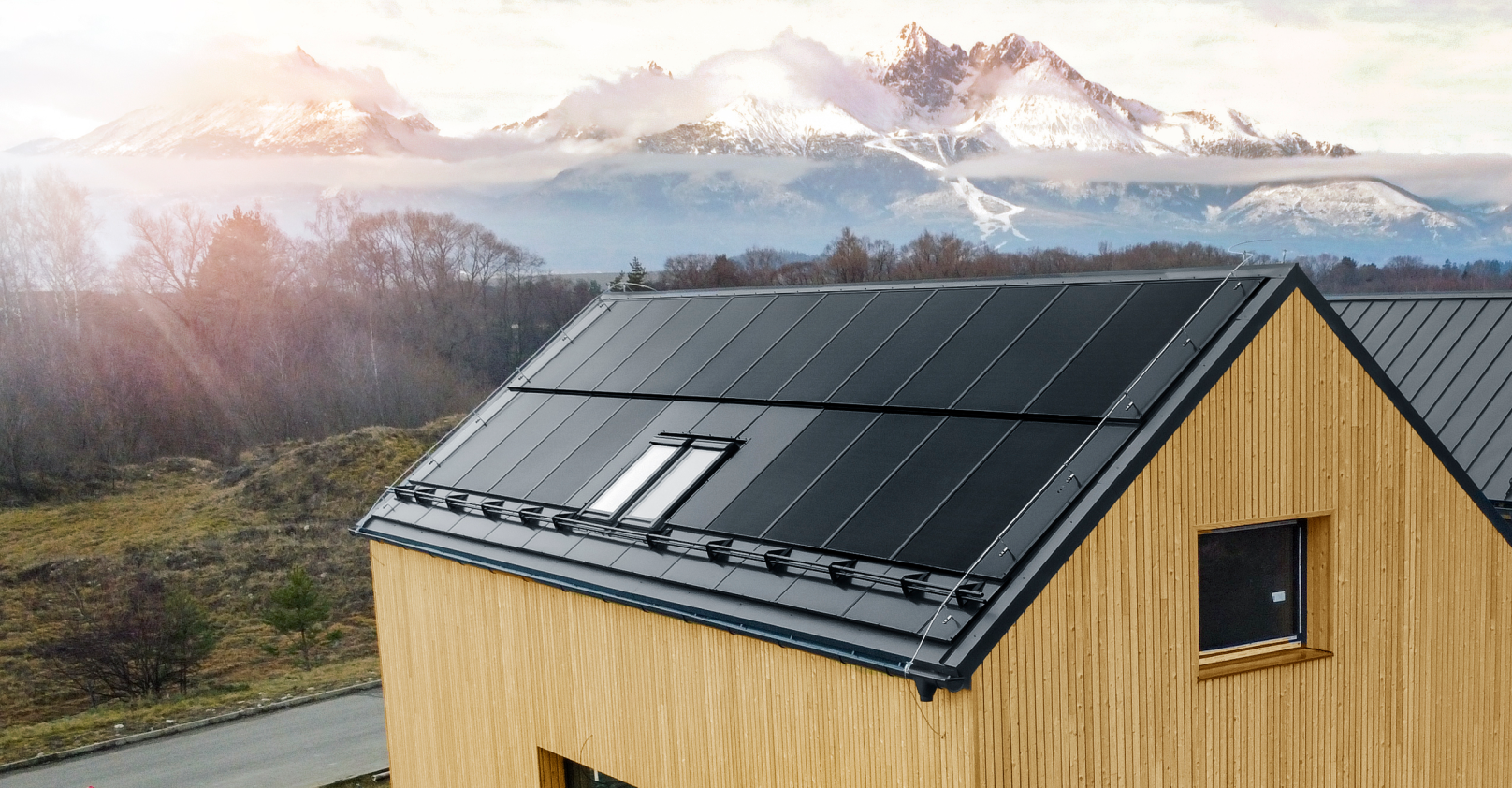 a house with a solar panel on the roof and mountains in the background