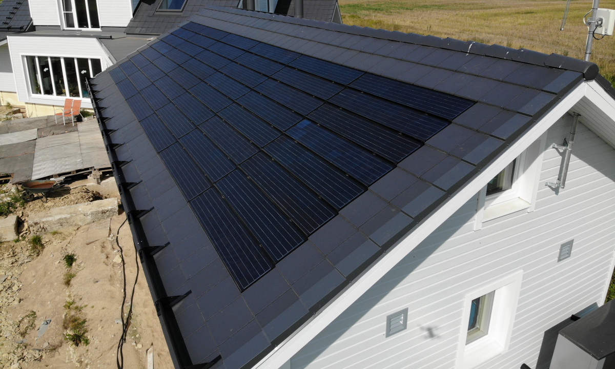 solarstone solar tiled roof on a white house with black roof tiles